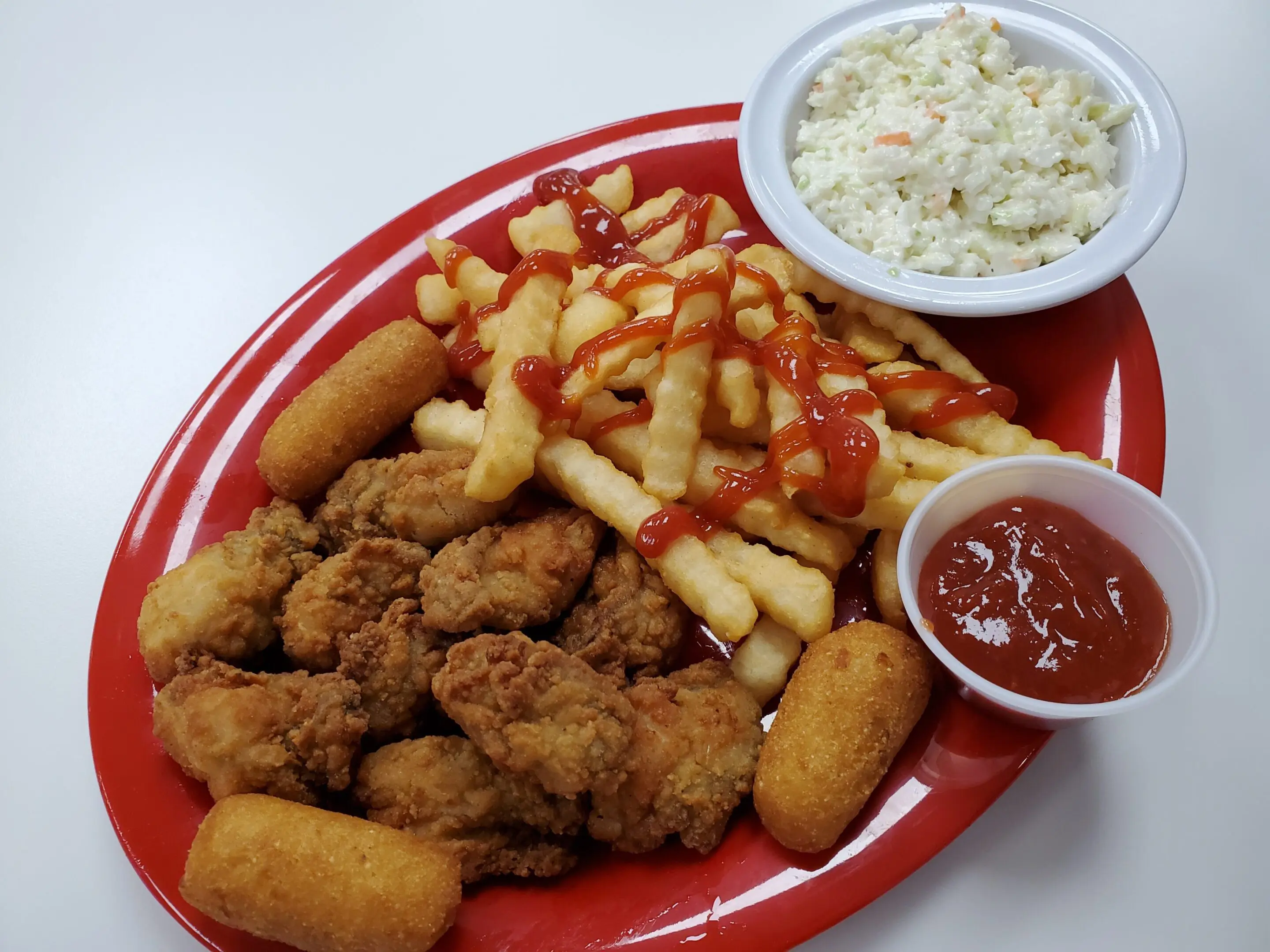 Fried chicken, fries, coleslaw, and ketchup platter.