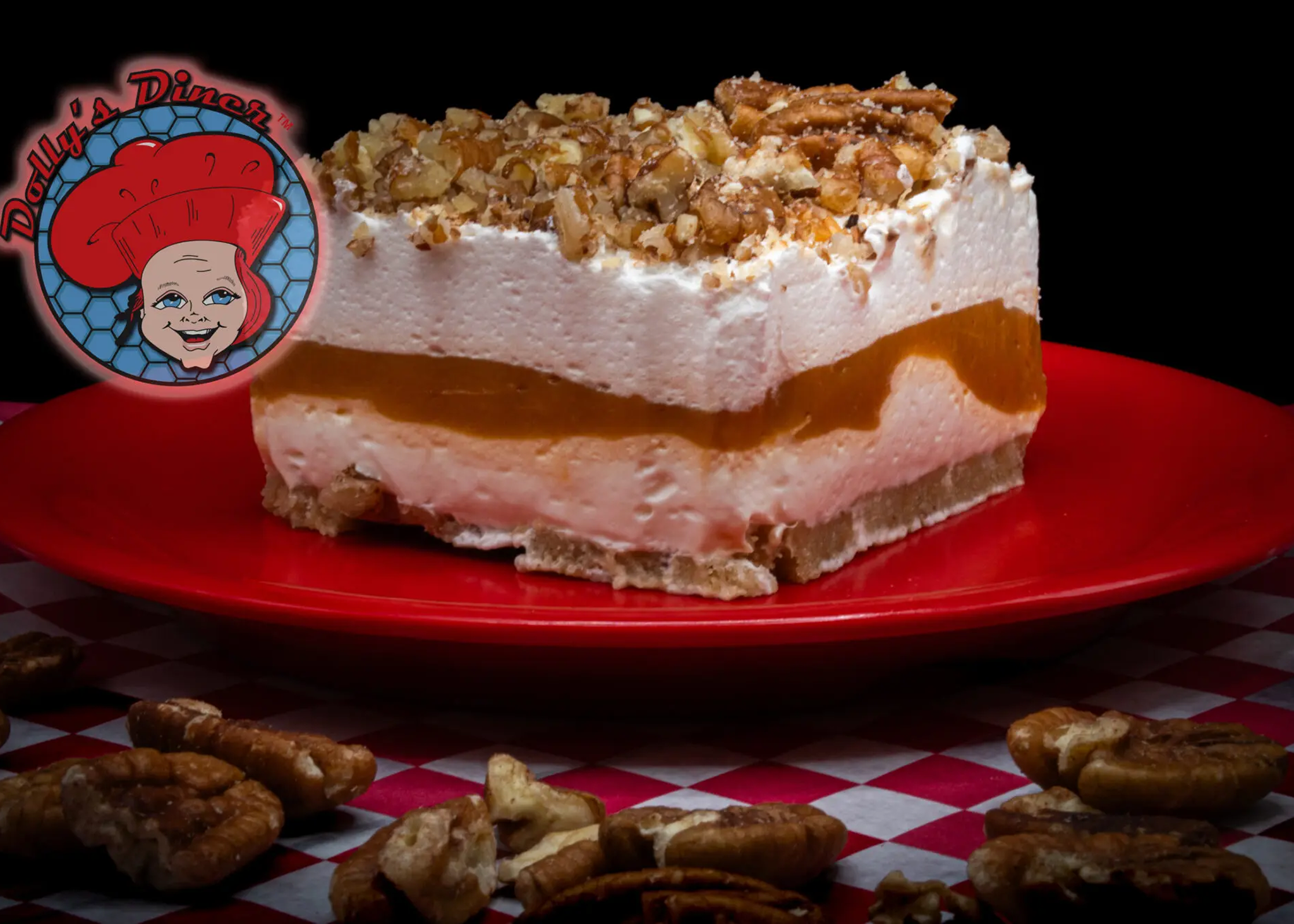 Layered dessert with nuts on red plate.