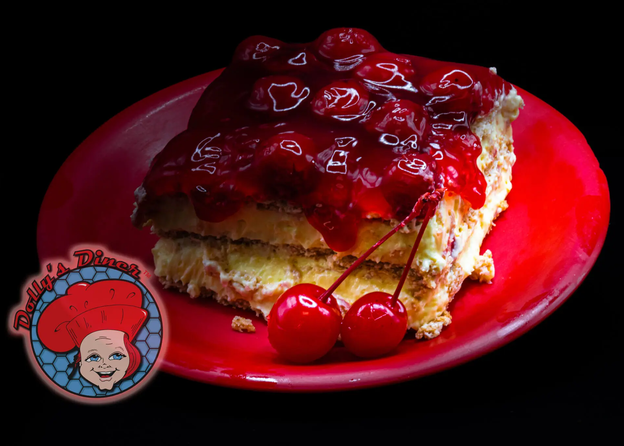 Cherry-topped cake slice on red plate.