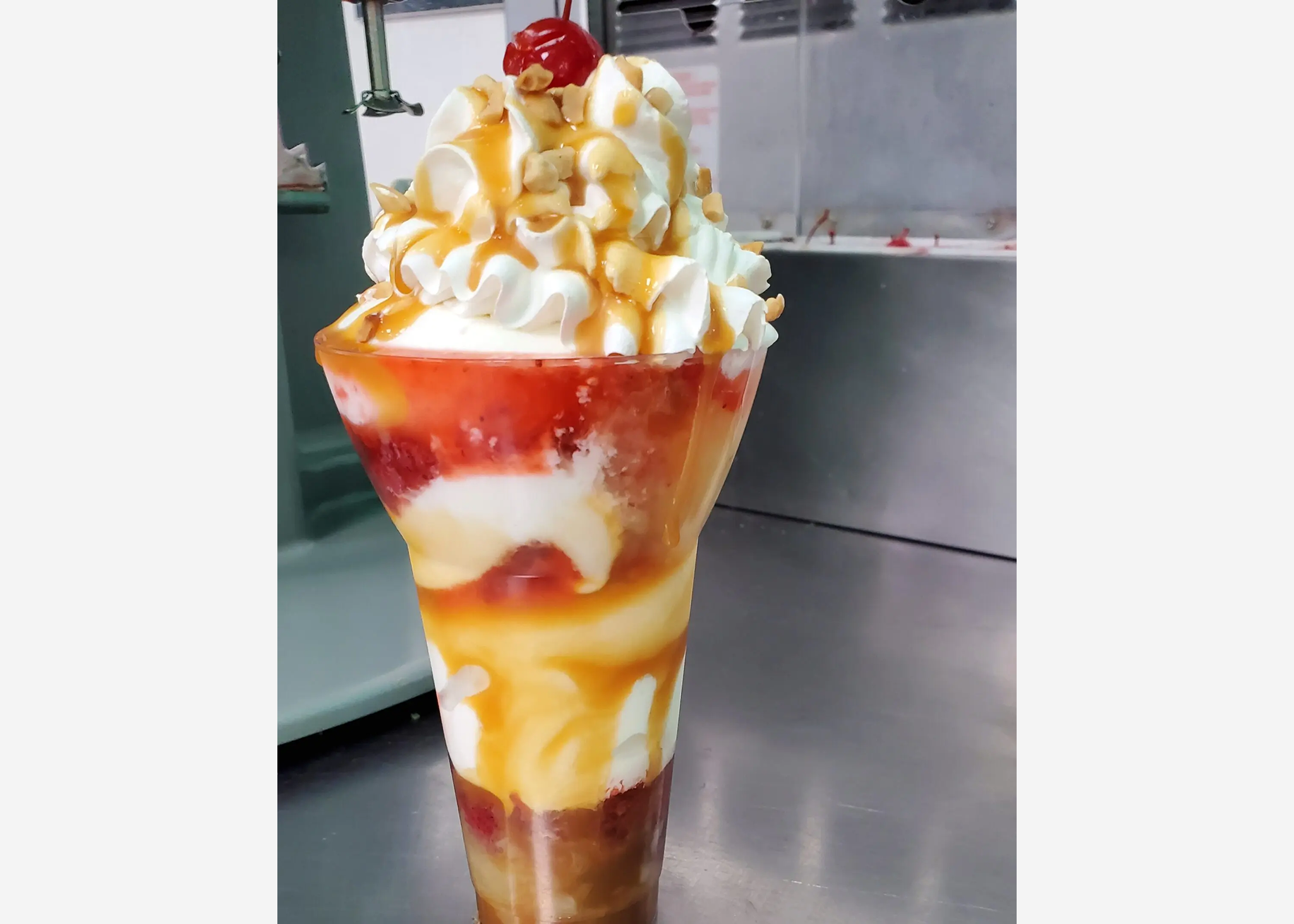 Tall dessert with whipped cream and cherry.