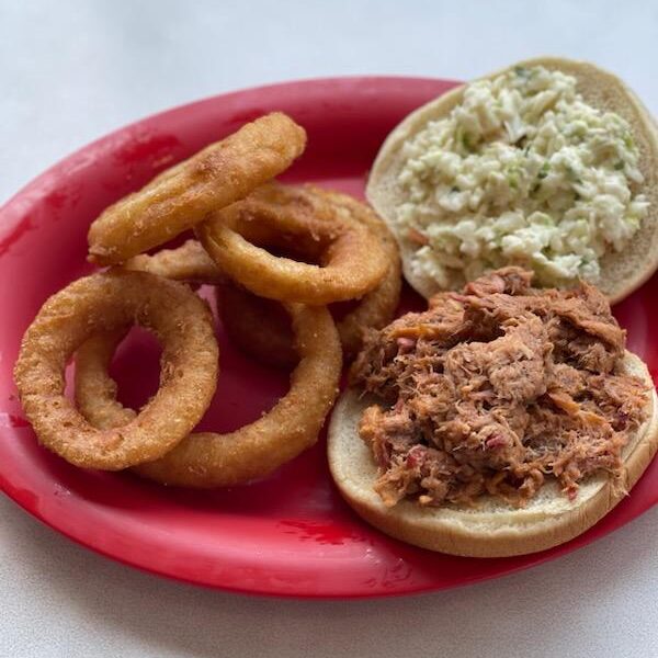 Pulled pork sandwich with onion rings.
