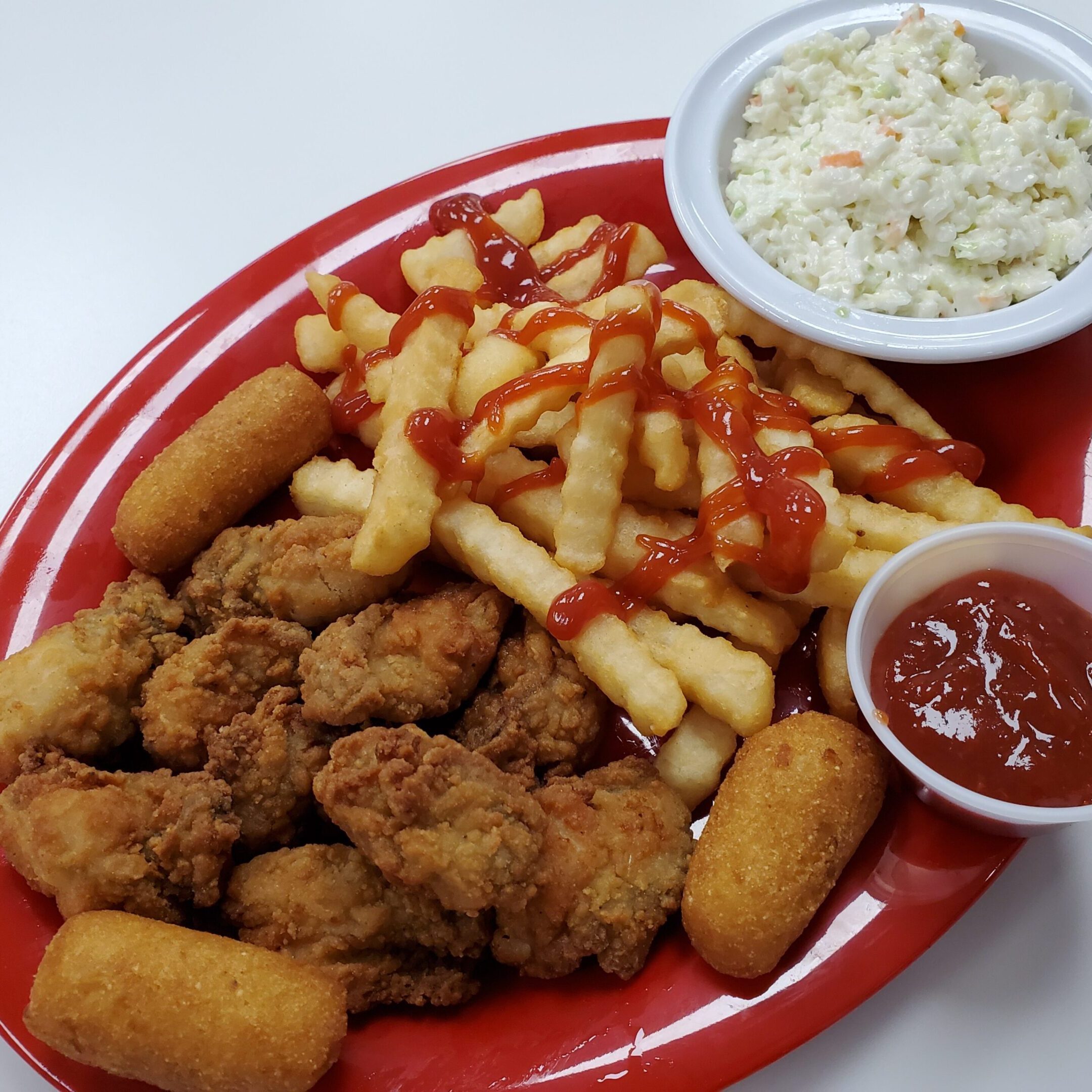 Fried chicken, fries, coleslaw, and ketchup platter.